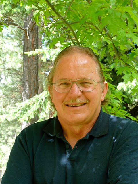 Smiling man with glasses outdoors among trees